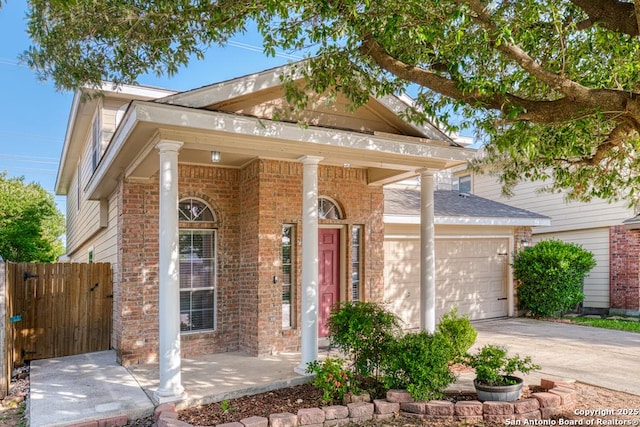 neoclassical / greek revival house with brick siding, concrete driveway, a garage, and fence