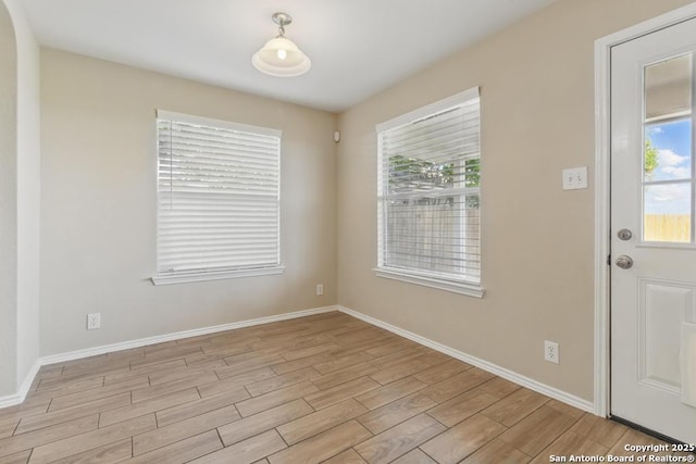 entrance foyer featuring light wood finished floors and baseboards