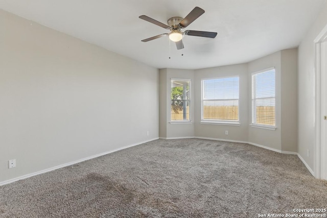 carpeted empty room featuring baseboards and ceiling fan