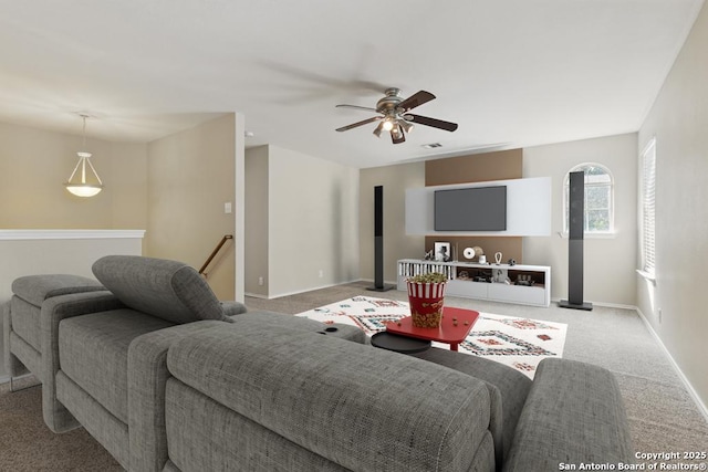 carpeted living room featuring a ceiling fan and baseboards