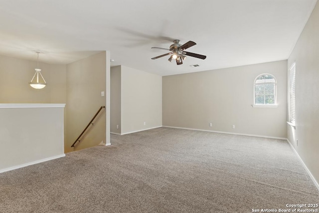 unfurnished room featuring carpet floors, a ceiling fan, and baseboards