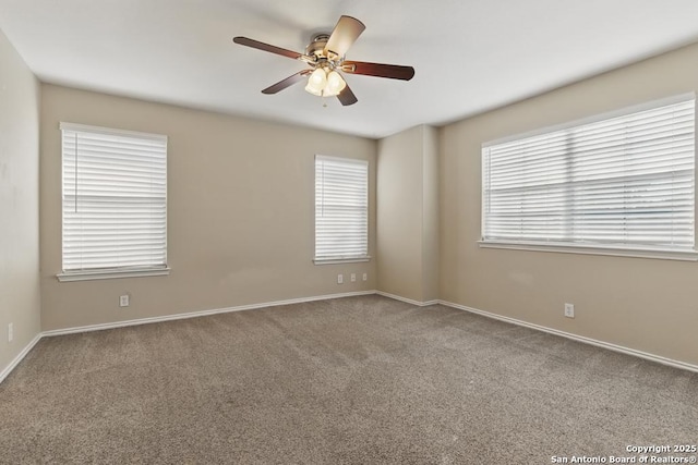 carpeted spare room featuring a ceiling fan and baseboards