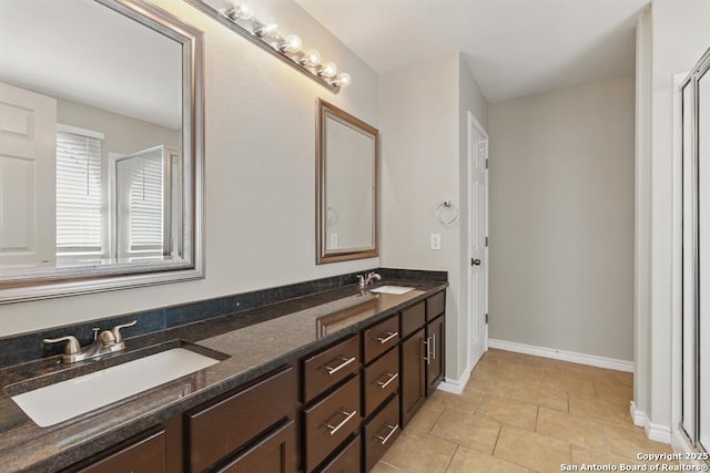 bathroom with tile patterned flooring, baseboards, and double vanity