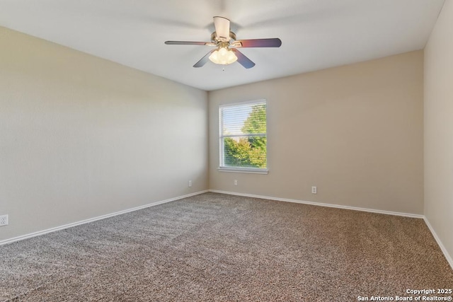 carpeted spare room featuring ceiling fan and baseboards