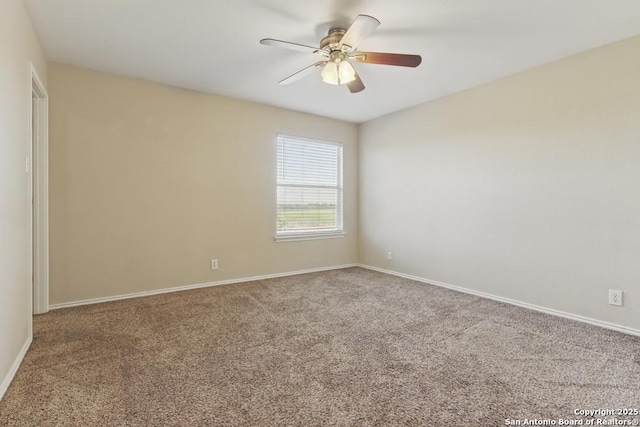 carpeted spare room with a ceiling fan and baseboards