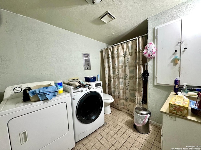 512 E Travis St, Luling, TX 78648 - washroom featuring a textured wall, washer and dryer, light tile patterned floors, and a textured ceiling