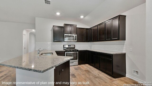 310 Steele Hbr, Cibolo, TX 78108 - kitchen featuring stainless steel appliances, light stone countertops, a peninsula, backsplash, and lofted ceiling
