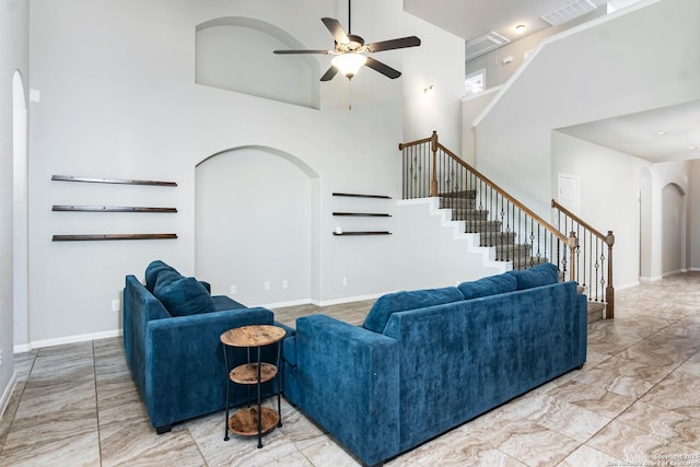 9870 Mulhouse, Schertz, TX 78154 - living room with arched walkways, a high ceiling, ceiling fan, stairs, and baseboards