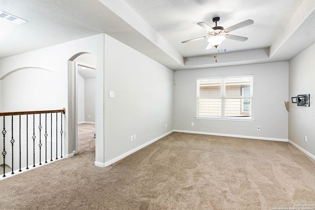 9870 Mulhouse, Schertz, TX 78154 - carpeted empty room featuring a ceiling fan, arched walkways, baseboards, and a raised ceiling