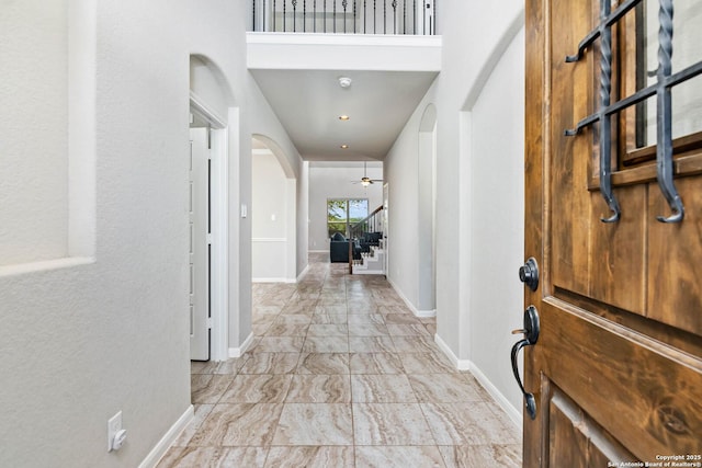 9870 Mulhouse, Schertz, TX 78154 - foyer featuring arched walkways, stairs, baseboards, ceiling fan, and light marble finish flooring