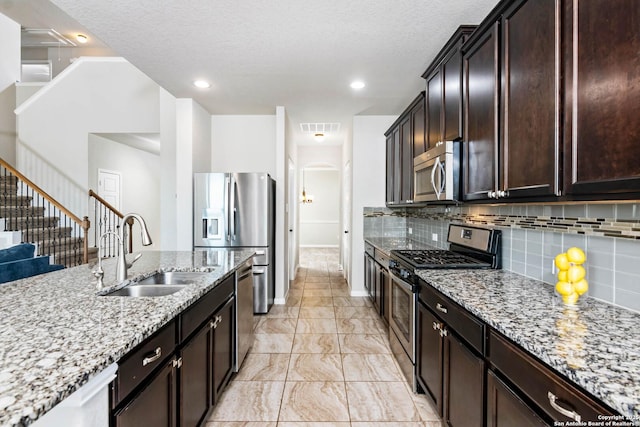 9870 Mulhouse, Schertz, TX 78154 - kitchen with stainless steel appliances, a sink, light stone countertops, decorative backsplash, and a textured ceiling