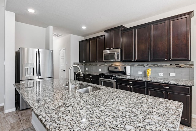 9870 Mulhouse, Schertz, TX 78154 - kitchen with appliances with stainless steel finishes, a sink, a center island with sink, baseboards, and tasteful backsplash