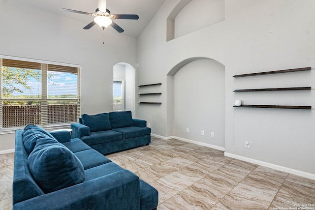 9870 Mulhouse, Schertz, TX 78154 - living area featuring arched walkways, ceiling fan, marble look tiles, high vaulted ceiling, and baseboards