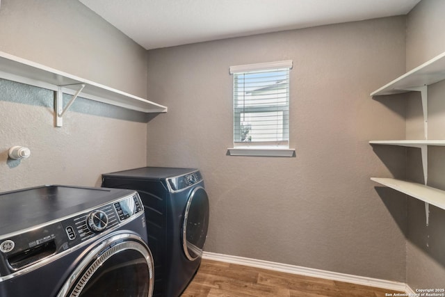 laundry room featuring washer and dryer, wood finished floors, and baseboards