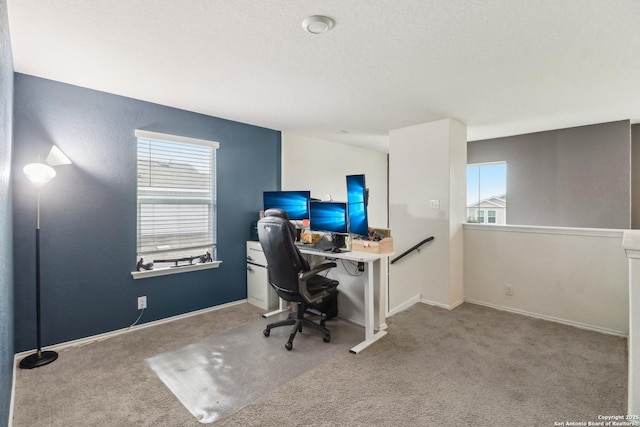 carpeted home office with baseboards and a textured ceiling