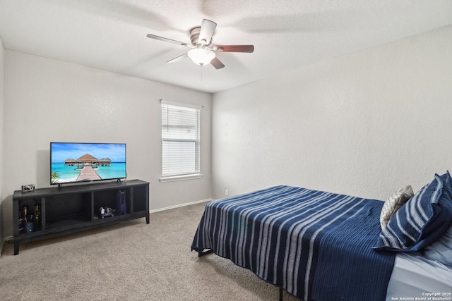 carpeted bedroom with a ceiling fan and baseboards