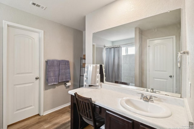 full bathroom featuring baseboards, wood finished floors, vanity, and a shower with curtain