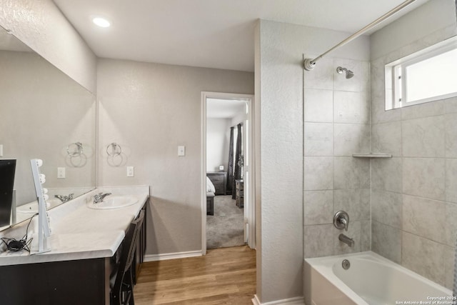 bathroom featuring wood finished floors,  shower combination, vanity, baseboards, and connected bathroom