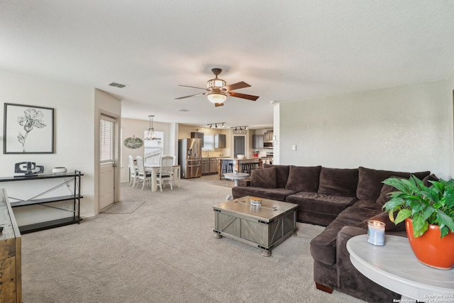 living area with light colored carpet, a ceiling fan, and baseboards