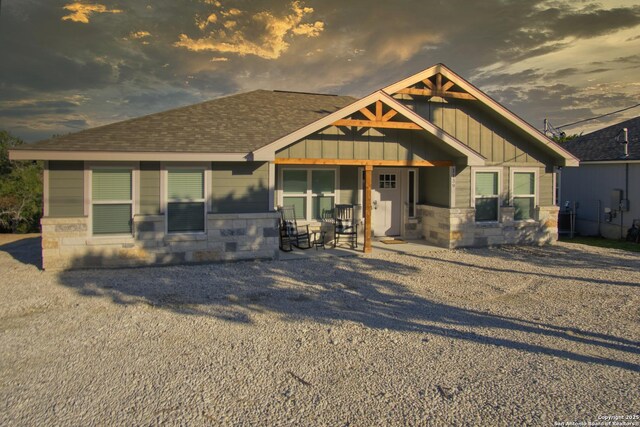 1139 Cedar Bnd, Canyon Lake, TX 78133 - view of front of house featuring board and batten siding, stone siding, and roof with shingles
