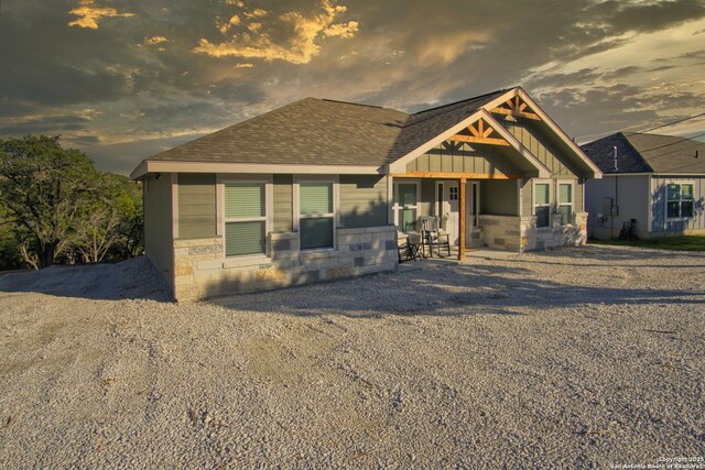 1139 Cedar Bnd, Canyon Lake, TX 78133 - view of front of home with stone siding, board and batten siding, and roof with shingles