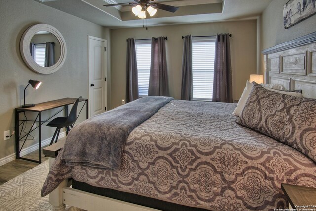 1139 Cedar Bnd, Canyon Lake, TX 78133 - bedroom with wood finished floors, baseboards, a ceiling fan, and a raised ceiling
