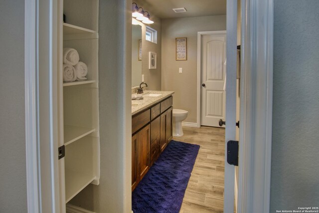 1139 Cedar Bnd, Canyon Lake, TX 78133 - bathroom featuring toilet, wood finished floors, and vanity