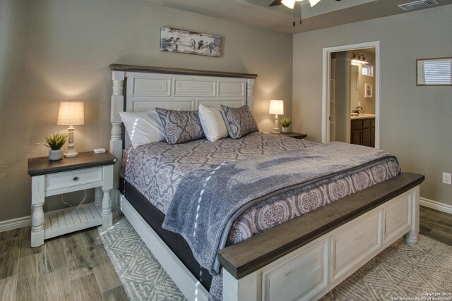 1139 Cedar Bnd, Canyon Lake, TX 78133 - bedroom featuring wood finished floors, baseboards, and ensuite bathroom