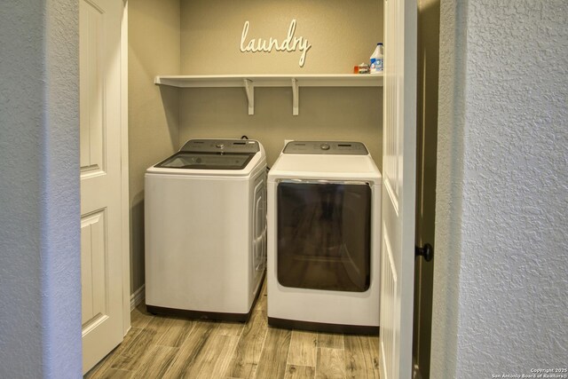 1139 Cedar Bnd, Canyon Lake, TX 78133 - laundry area featuring washer and clothes dryer, light wood-type flooring, and a textured wall