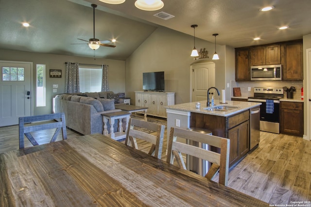 1139 Cedar Bnd, Canyon Lake, TX 78133 - kitchen featuring stainless steel appliances, a sink, ceiling fan, light wood-style floors, and vaulted ceiling
