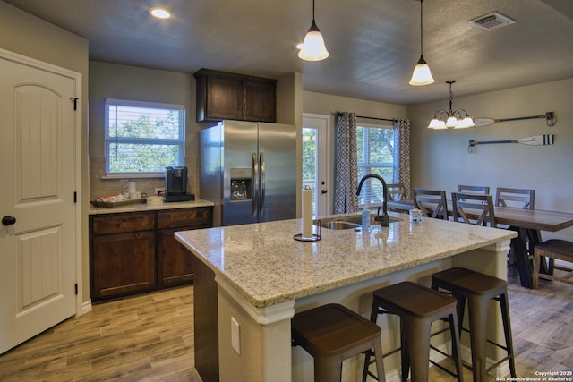 1139 Cedar Bnd, Canyon Lake, TX 78133 - kitchen featuring stainless steel refrigerator with ice dispenser, a sink, light wood-style flooring, a breakfast bar, and recessed lighting