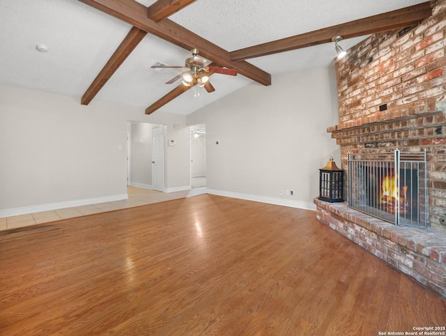 unfurnished living room featuring a fireplace, wood finished floors, a ceiling fan, and baseboards