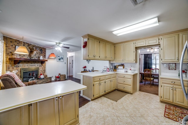 10180 Aliann, Atascosa, TX 78002 - kitchen featuring a ceiling fan, light countertops, a fireplace, light tile patterned floors, and cream cabinetry