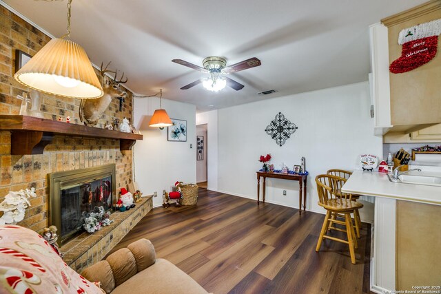 10180 Aliann, Atascosa, TX 78002 - living area with ceiling fan, dark wood-style flooring, a fireplace, and baseboards