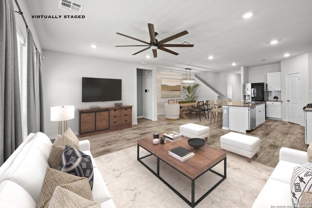 living area with recessed lighting, a ceiling fan, and light wood-style flooring