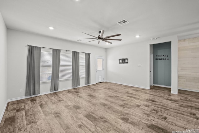 spare room featuring ceiling fan, plenty of natural light, wood finished floors, and recessed lighting