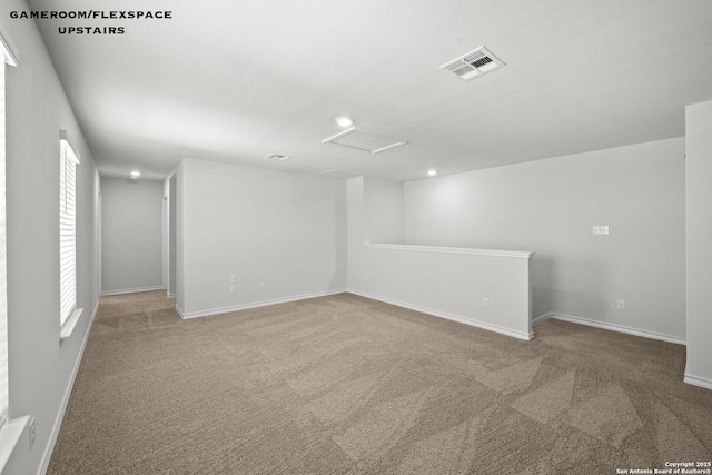 carpeted empty room featuring attic access, baseboards, and recessed lighting