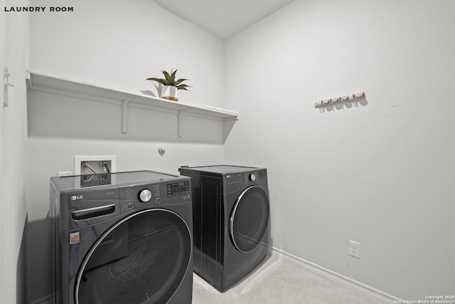 laundry room with washing machine and dryer and baseboards