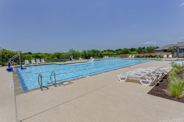 community pool with fence and a patio