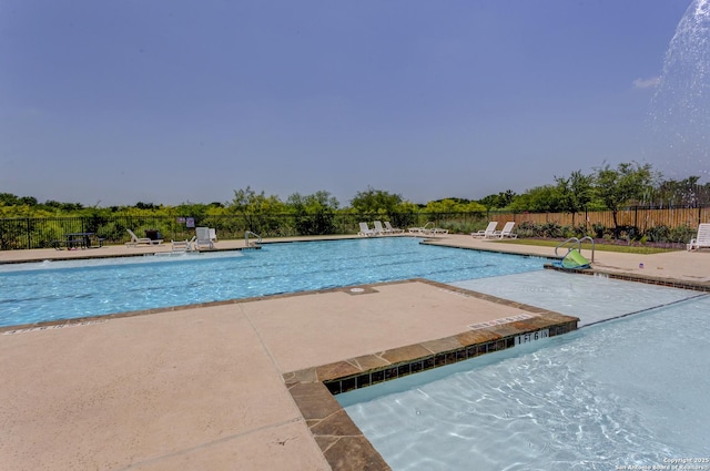 community pool with a patio and fence