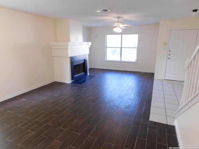 8918 Kenton Mist, San Antonio, TX 78240 - unfurnished living room featuring dark wood-type flooring, ceiling fan, a fireplace, and baseboards