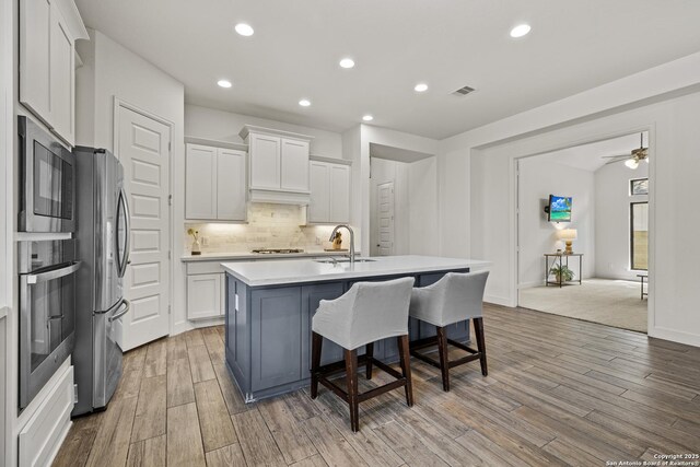 435 Bridle Trl, New Braunfels, TX 78132 - kitchen featuring appliances with stainless steel finishes, white cabinets, tasteful backsplash, a sink, and light countertops