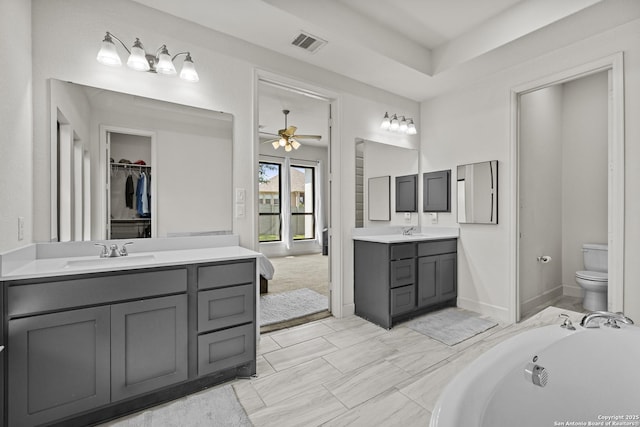435 Bridle Trl, New Braunfels, TX 78132 - full bath featuring ceiling fan, toilet, two vanities, a bathtub, and baseboards