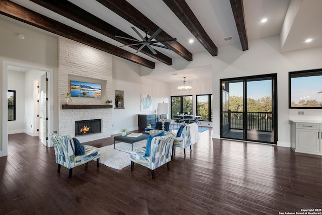 3045 Campestres, Spring Branch, TX 78070 - living room featuring a large fireplace, beamed ceiling, a ceiling fan, wood finished floors, and a chandelier