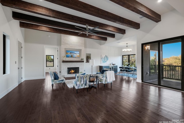 3045 Campestres, Spring Branch, TX 78070 - living room with a large fireplace, beam ceiling, a chandelier, a ceiling fan, and wood finished floors