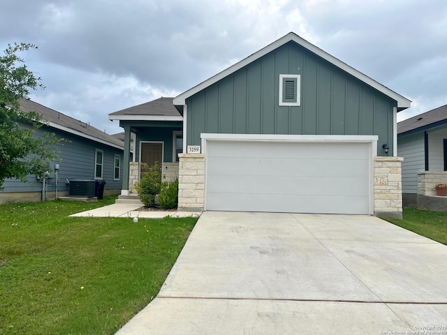 view of front of house with board and batten siding, a front yard, driveway, an attached garage, and stone siding