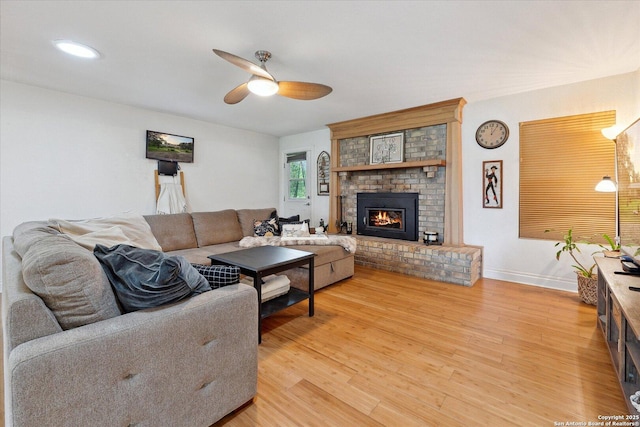 101 Cynthia, Pleasanton, TX 78064 - living room with a ceiling fan, a brick fireplace, light wood-type flooring, and baseboards
