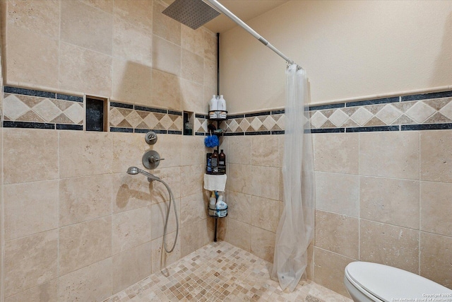 101 Cynthia, Pleasanton, TX 78064 - bathroom with tiled shower, tile walls, and toilet