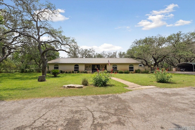 101 Cynthia, Pleasanton, TX 78064 - ranch-style house with a carport, metal roof, and a front lawn