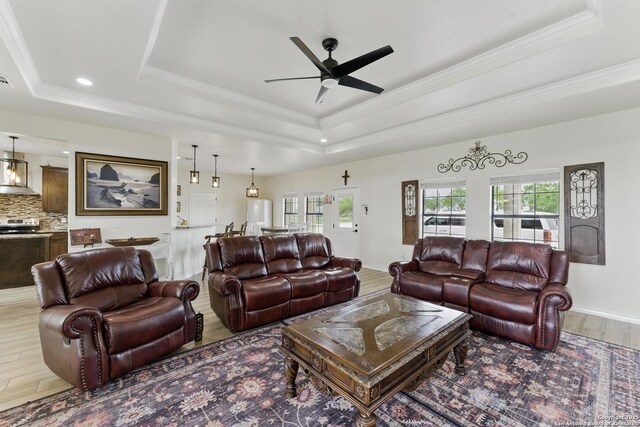 1110 Atascosa County Road 101, Floresville, TX 78114 - living area with a raised ceiling, wood finished floors, ceiling fan, ornamental molding, and recessed lighting